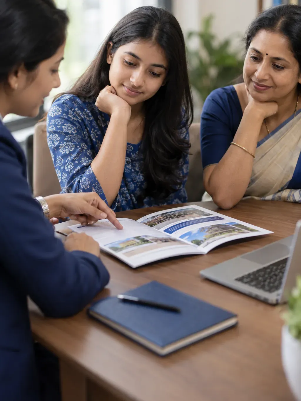 Counsellor pointing at a course brochure for a student and her mother